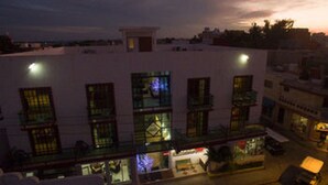 A multi-story building with large windows and balconies. - Hotel Isleño (Isla Mujeres)