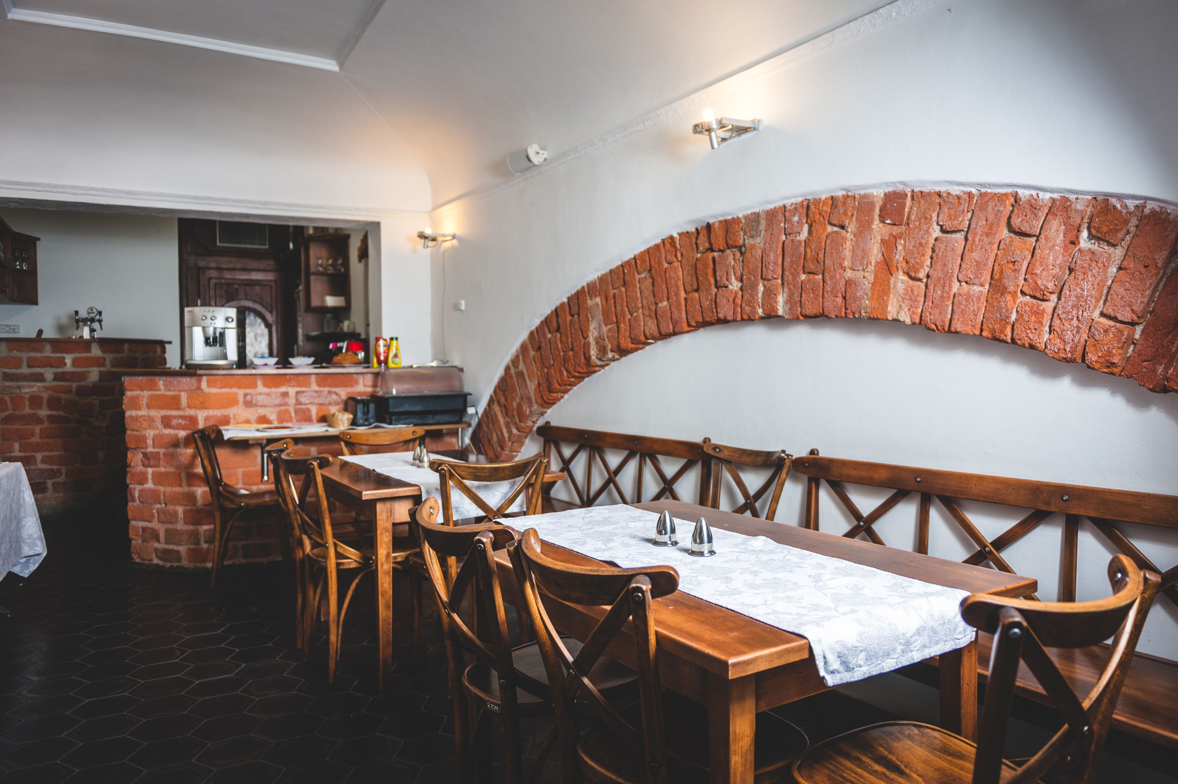 A restaurant with brick walls, wooden tables, and chairs.