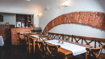 A restaurant with brick walls, wooden tables, and chairs.