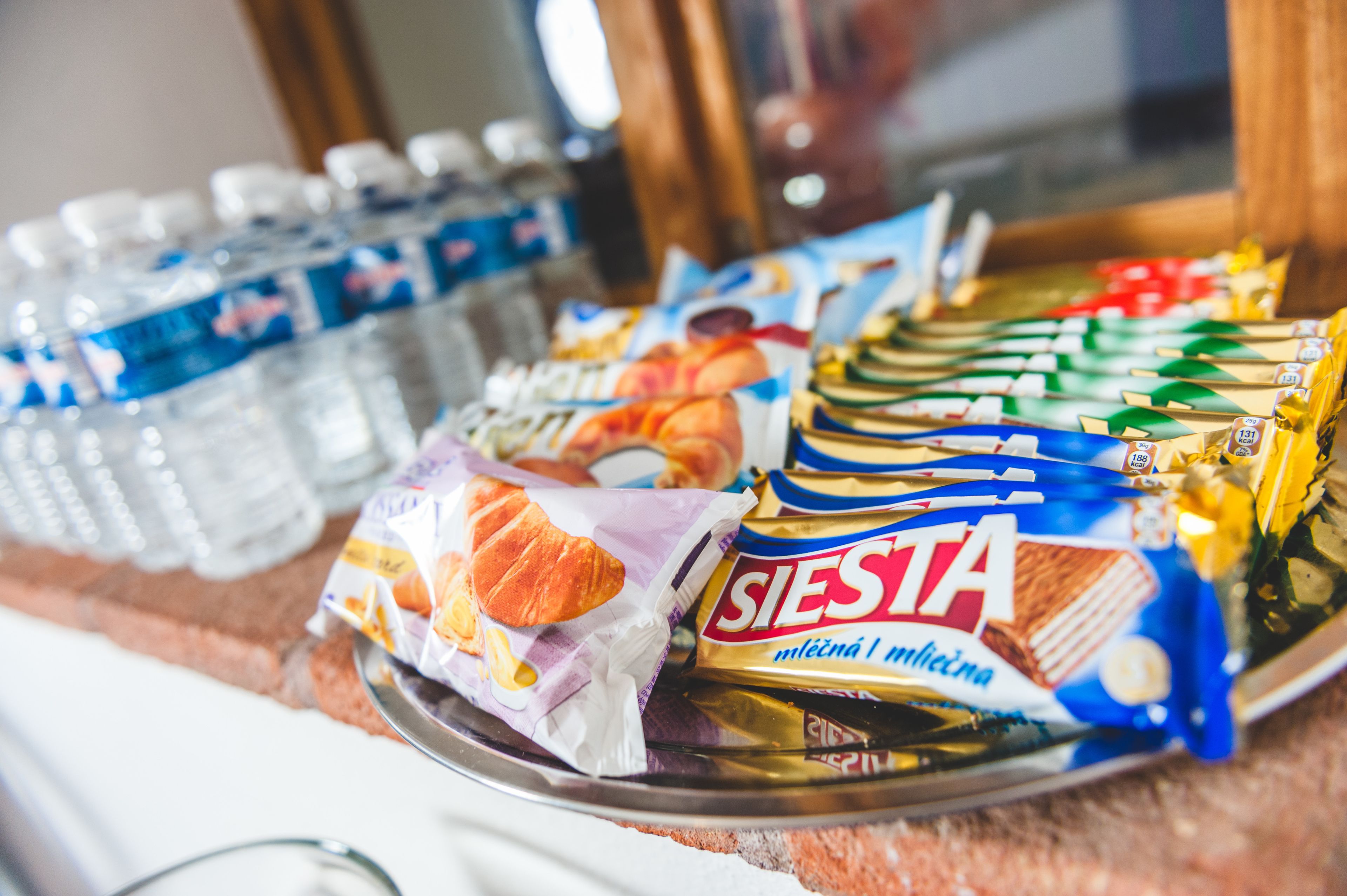 Una bandeja con distintos alimentos, como aperitivos envasados y agua embotellada.
