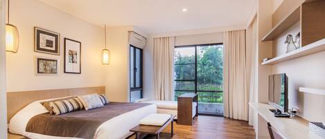 A modern hotel room with a large bed, a desk, and a TV.