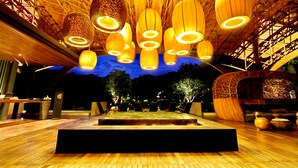 A spacious indoor area with a wooden floor, multiple hanging light fixtures, and a central stage. - Veranda Chiang Mai Suite (Hang Dong)