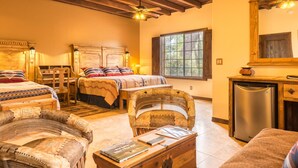 A cozy room with two beds, a wooden chest, and a desk with a chair. - White Stallion Ranch (Tucson)