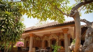 A building with a covered patio area, columns, and outdoor seating. - Zen Resort Bali (Buleleng)