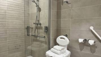 A modern bathroom with a glass-enclosed shower, a white toilet, and a towel rack.