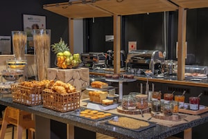 Buffet com diversos alimentos, incluindo doces, frutas e bebidas.