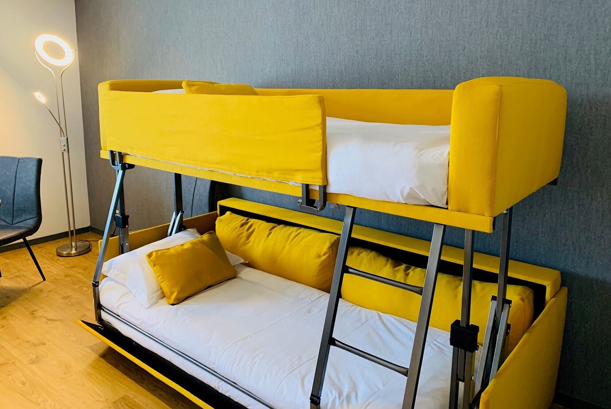 Una cama litera con ropa de cama amarilla y un colchón blanco.