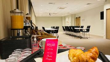 A breakfast setup with a croissant on a tray, a coffee machine, and a sign for Richard Blanc tea.