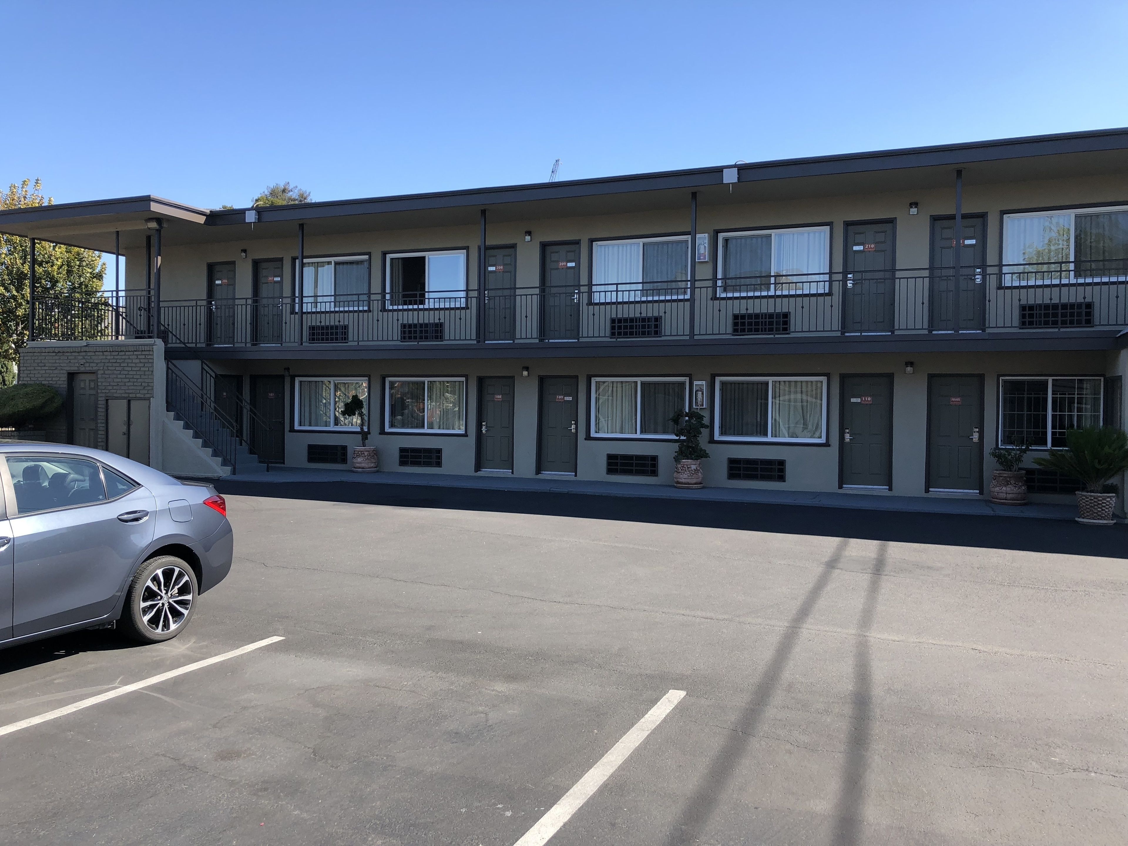 A multi-story building with a parking lot in front.