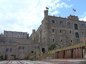 A historic stone building with multiple windows and a flag. - Hotel Castillo Santa Cecilia (Guanajuato)