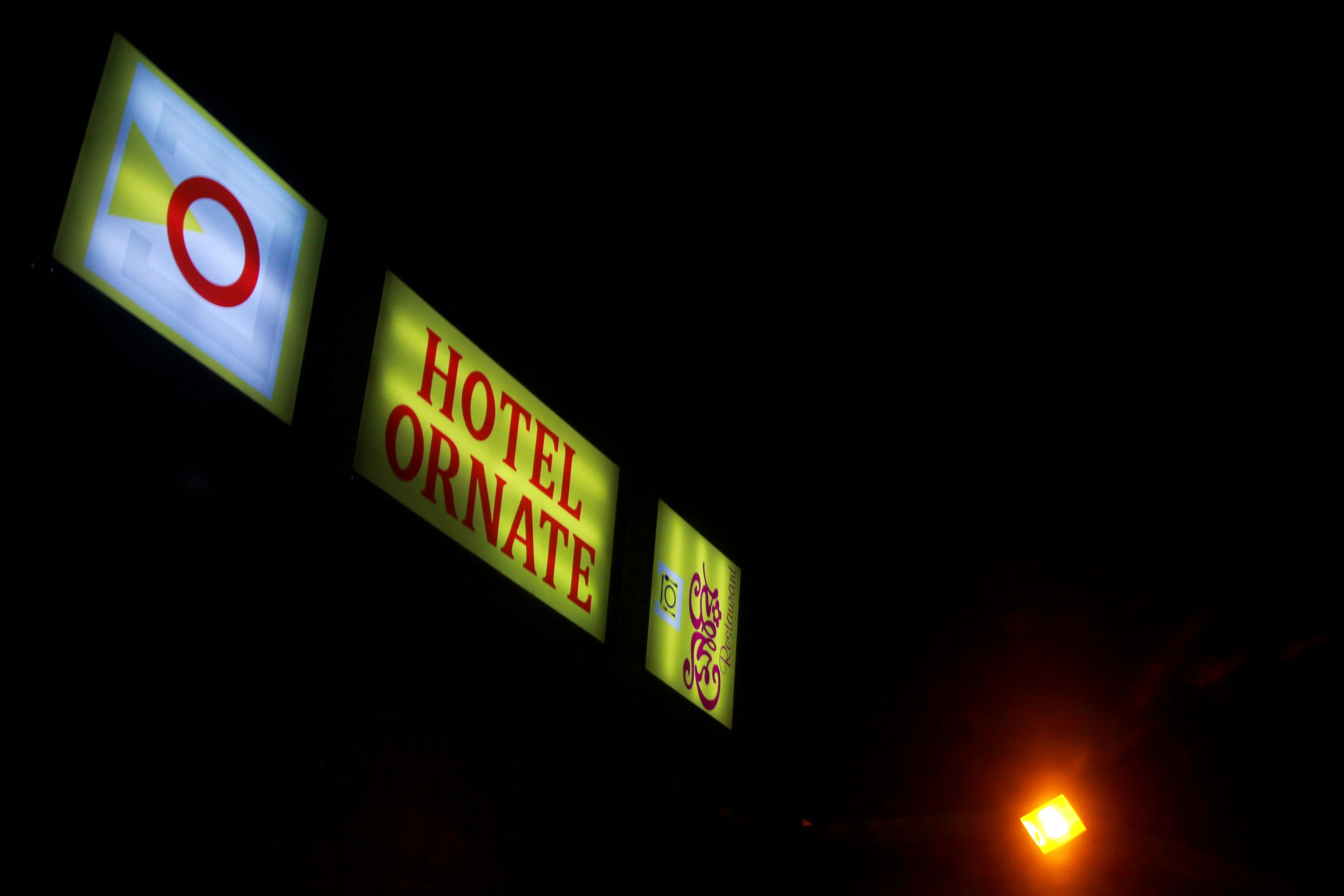 Illuminated signs for a hotel with a prominent 'HOTEL ORNATE' sign.