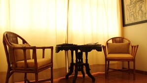 Two wicker chairs with cushions, a small table with papers, and a framed picture on the wall. - Casa Tlaquepaque (Tlaquepaque)