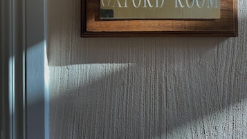 A sign labeled "OXFORD ROOM" on a textured wall.