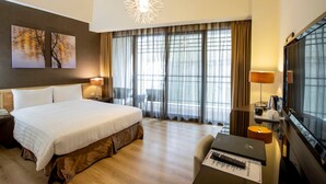 A hotel room with a large bed, a desk with a laptop, a TV, and a window with curtains. - Lealea Garden Hotel Moon (Yuchi)