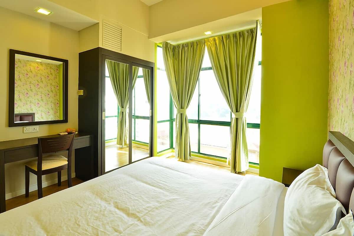A hotel room with a bed, a desk, and a chair.