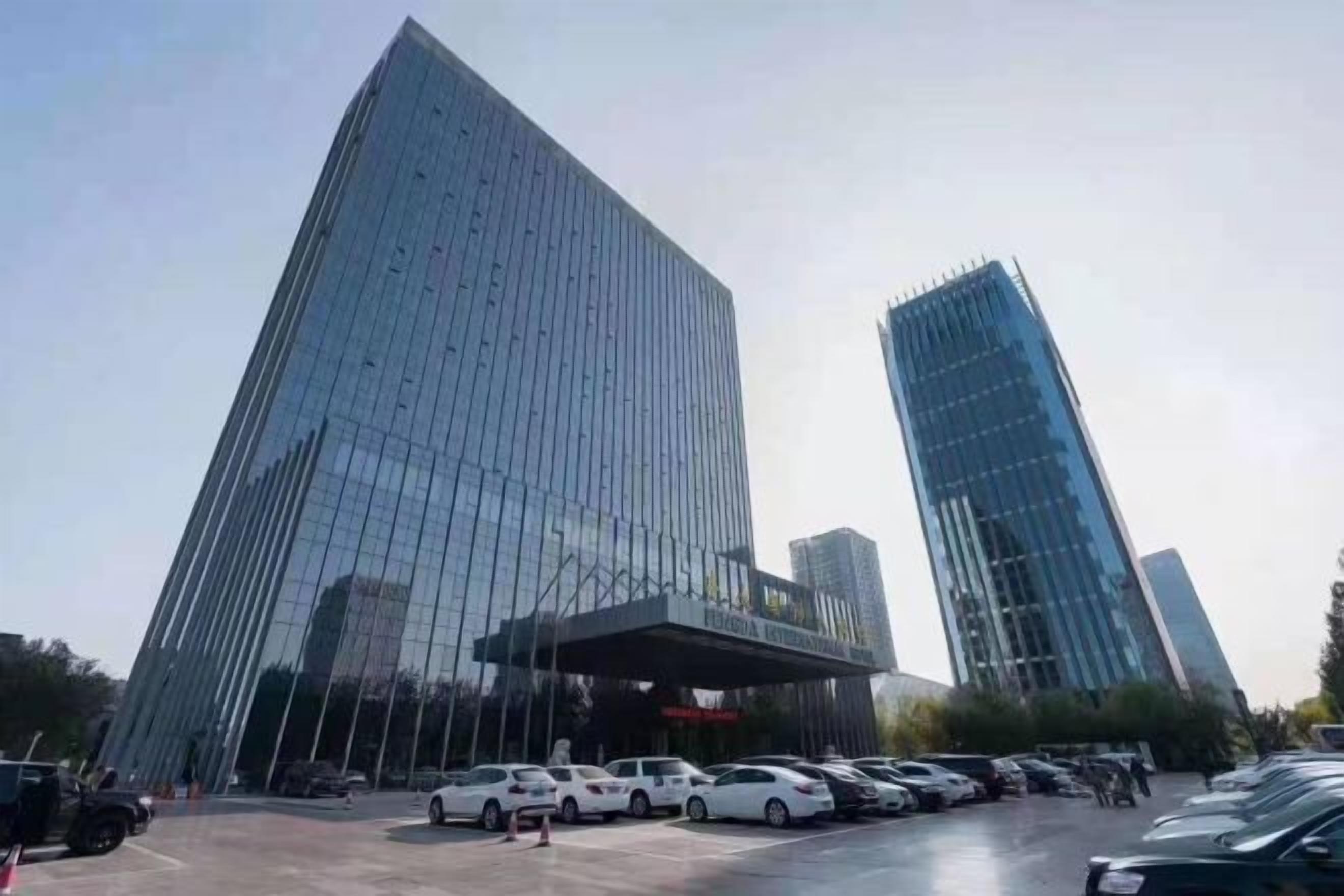 A modern building with a glass facade and a covered entrance.