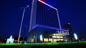 A modern hotel with a prominent vertical light display and a sign indicating it is the Fengda International Hotel.