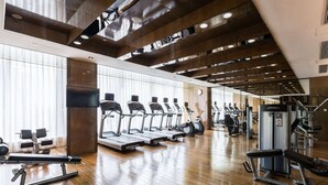 Une salle de sport équipée de tapis de course, de vélos d’appartement et d’appareils de musculation.