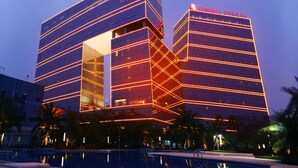 Un bâtiment moderne, facilement reconnaissable grâce à son grand panneau « RANADA PLAZA », qui se distingue par sa façade géométrique originale et ses fenêtres en verre réfléchissant.