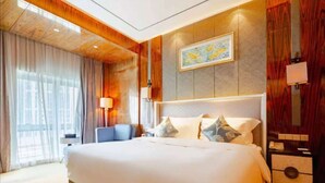 Une chambre d’hôtel avec un grand lit, un bureau, une chaise et une fenêtre avec des rideaux.