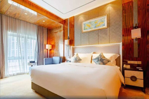 Una habitación de hotel con una cama grande, un escritorio, una silla y una ventana con cortinas.