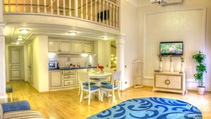 A spacious living area with a dining table and chairs, a sofa, and a kitchen in the background. - Metro Hotel Apartments (Odesa)