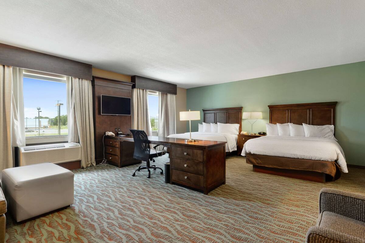 Een hotelkamer met een bed, bureau, stoel en een televisie.