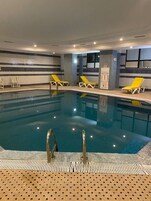 Una piscina al aire libre, sombrillas, tumbonas