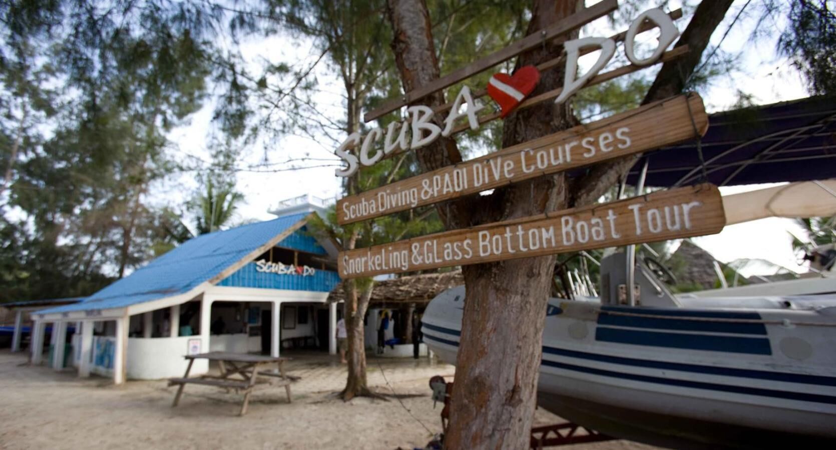 Un letrero de madera que anuncia diversos cursos de buceo y snorkel.