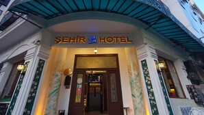 A hotel entrance with a sign reading 'SEHIR HOTEL,' a staircase leading up to the entrance, and a decorative awning above. - Sehir Hotel Old City (Istanbul)