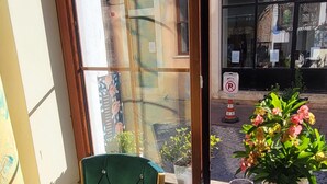 A corner room with a green chair, a small table with a drink, a magazine, and a potted plant. - Sehir Hotel Old City (Istanbul)