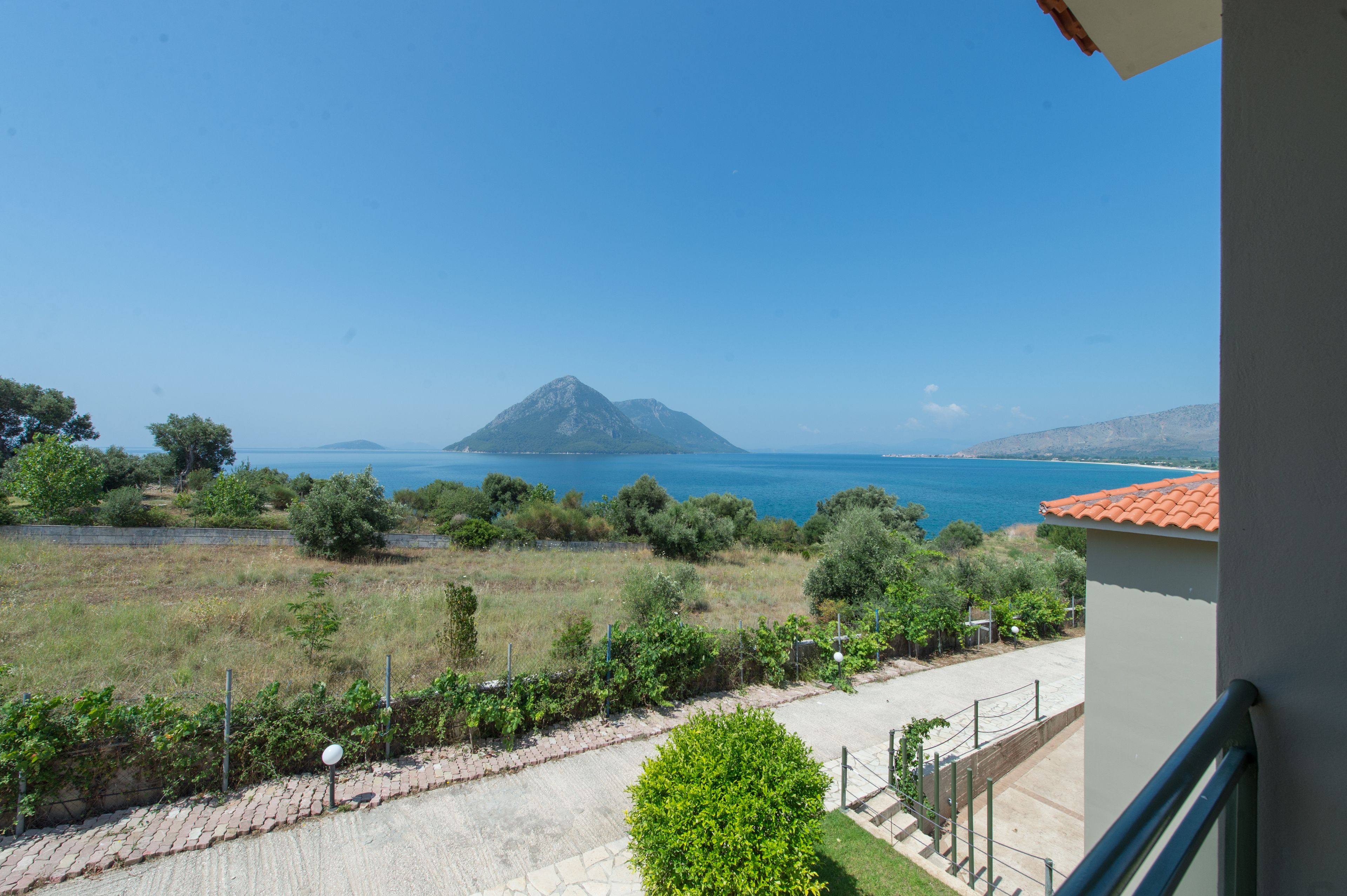 Un balcon avec vue sur la montagne et la mer.