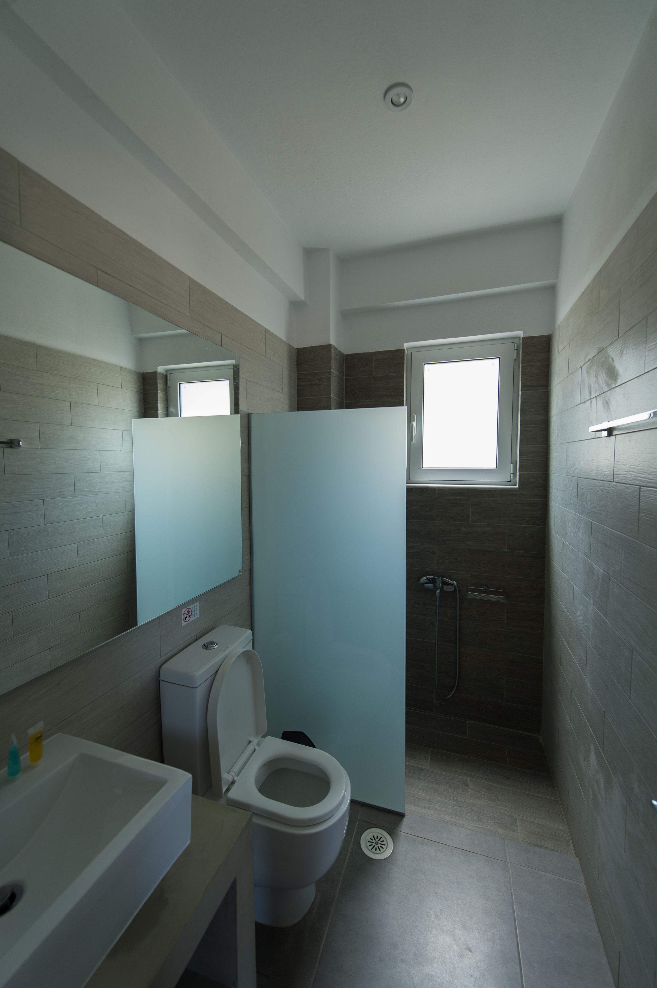 A modern bathroom with a toilet, sink, and shower.
