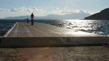 Un muelle se adentra en el agua, con una persona al final.