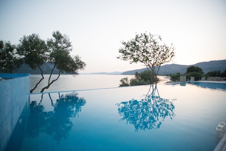 Una piscina techada, una piscina al aire libre de temporada, sombrillas. Thesmos Village