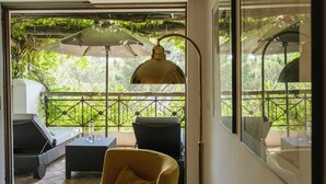 Una habitación con una puerta de cristal que da a un patio exterior, amoblada con un sofá, sillas y una mesa.