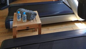 Gimnasio en casa con cinta de correr, elíptica y pesas.