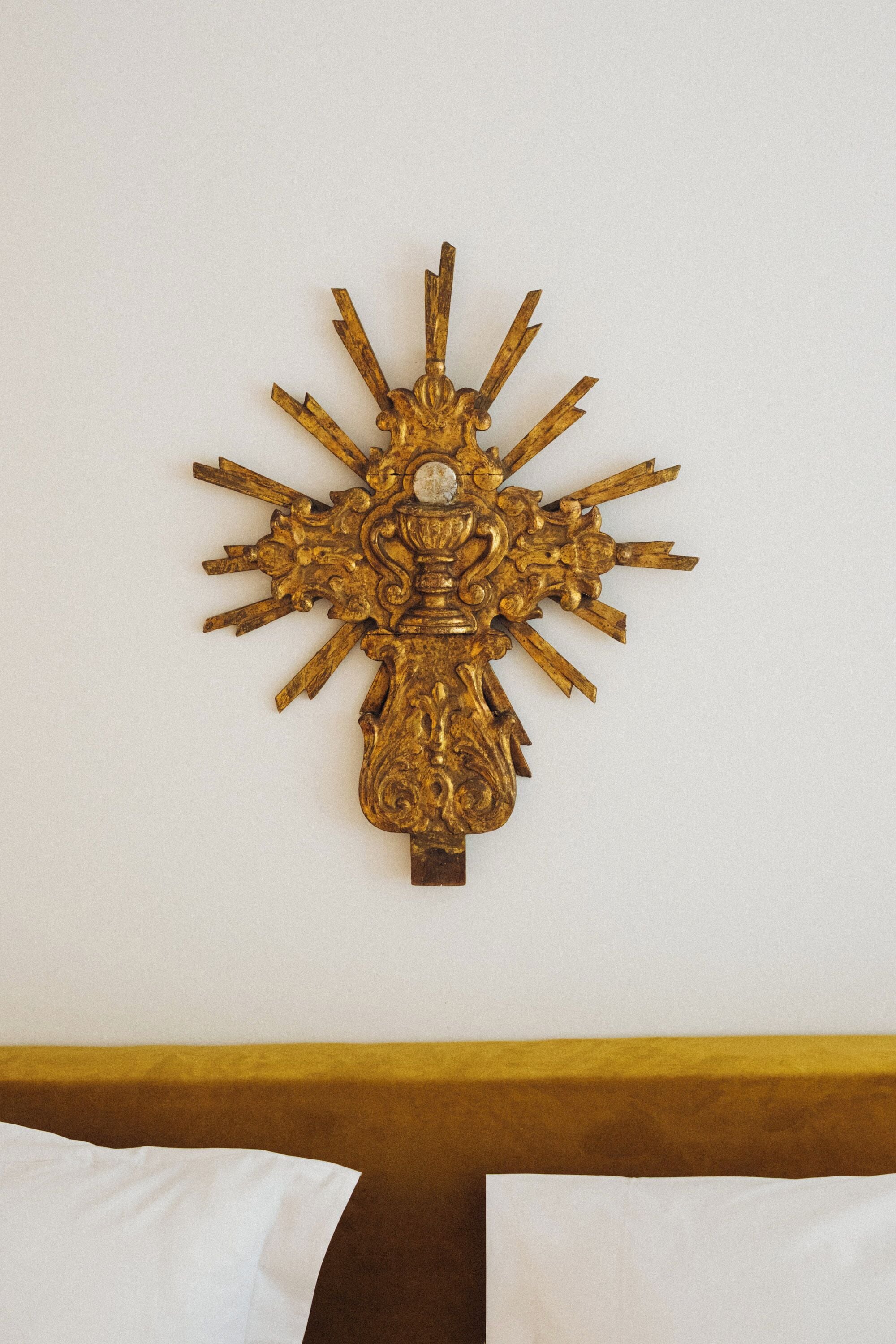 A wall-mounted golden decorative piece with a central figure and radiating elements.