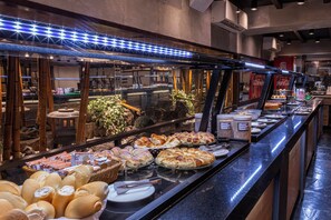A buffet with various food items and a glass display case. - Nikkey Palace Hotel (São Paulo)