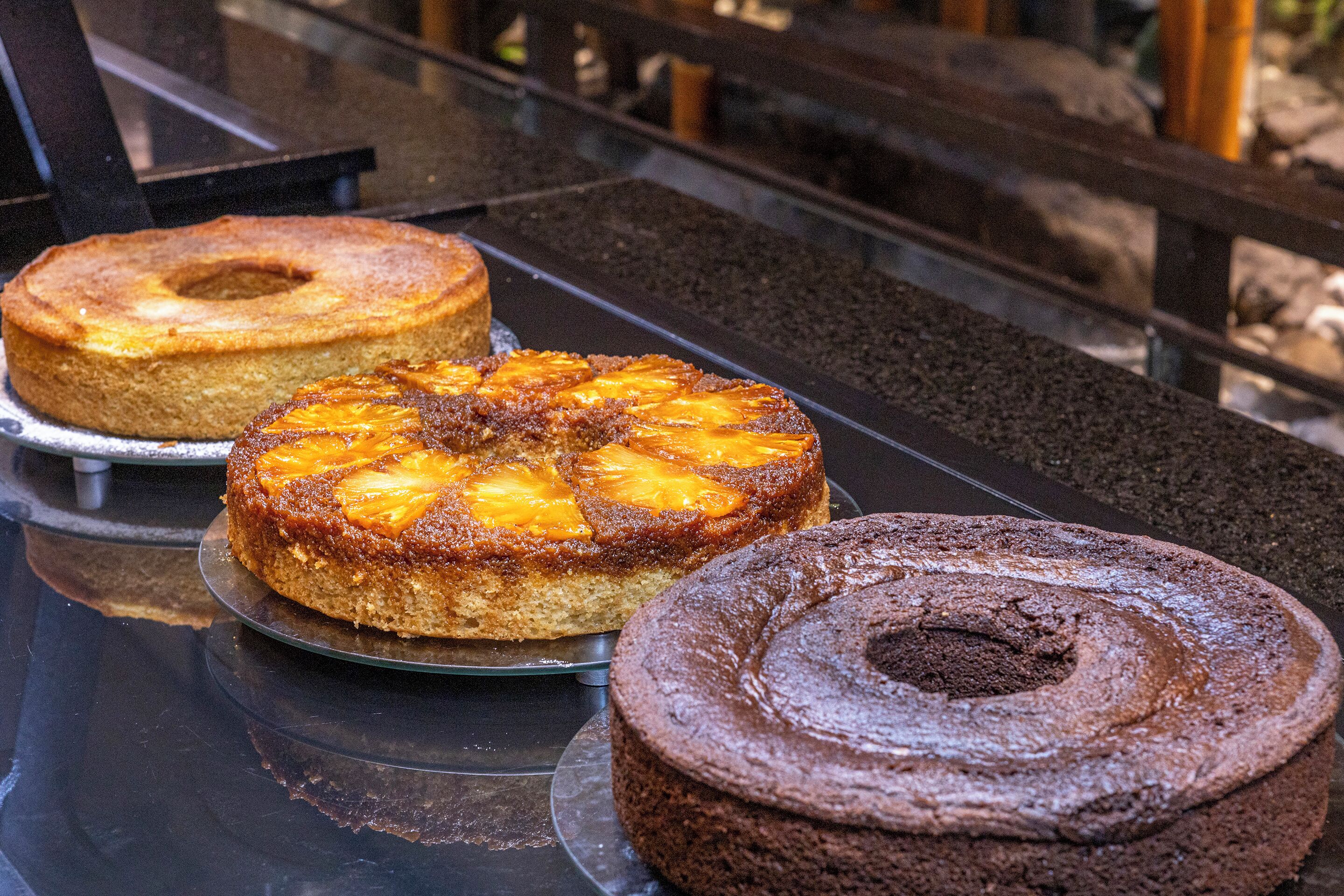 Trois gâteaux sur une surface réfléchissante.