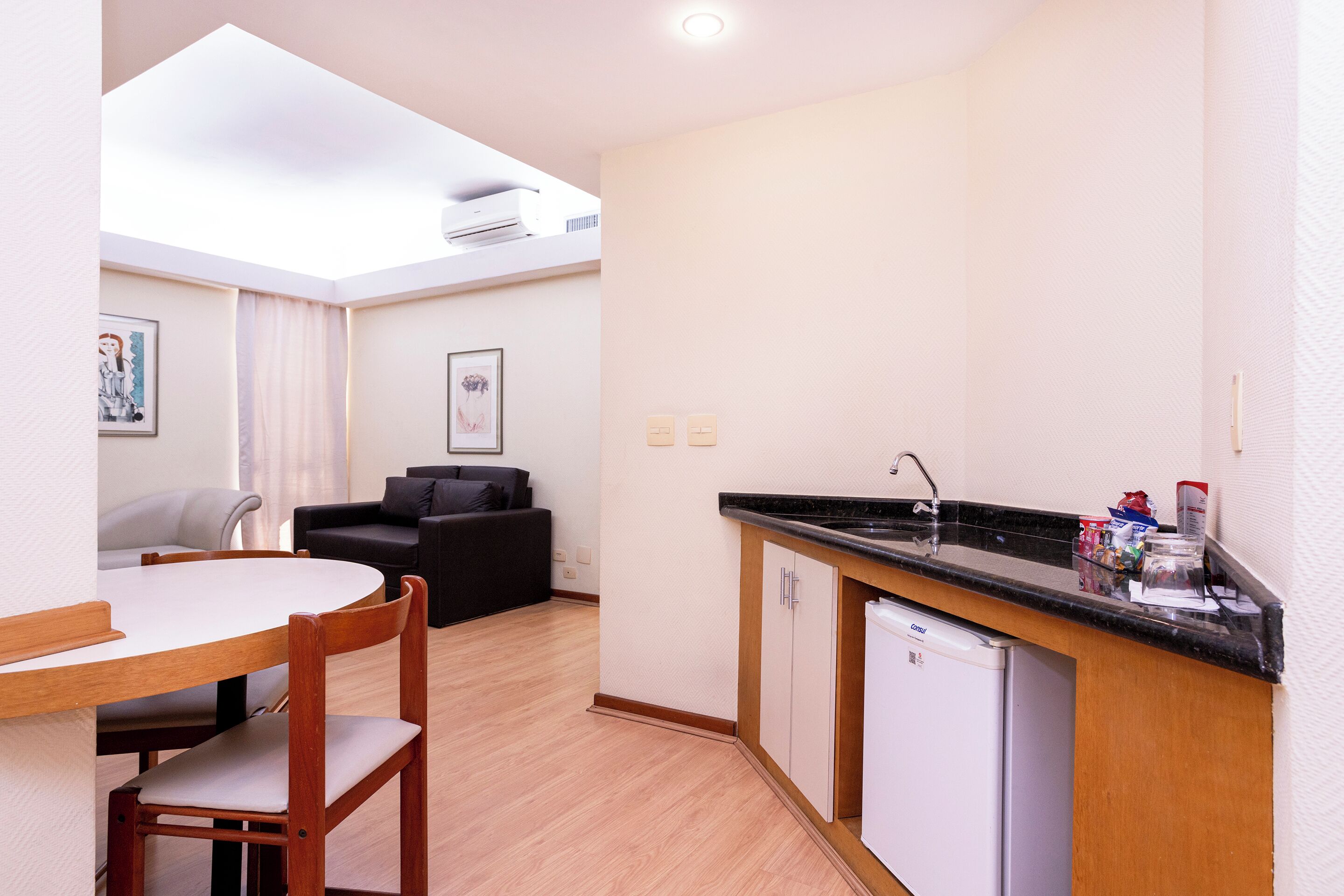 A compact kitchen with a dishwasher, a small countertop, and a dining area with a table and chairs.
