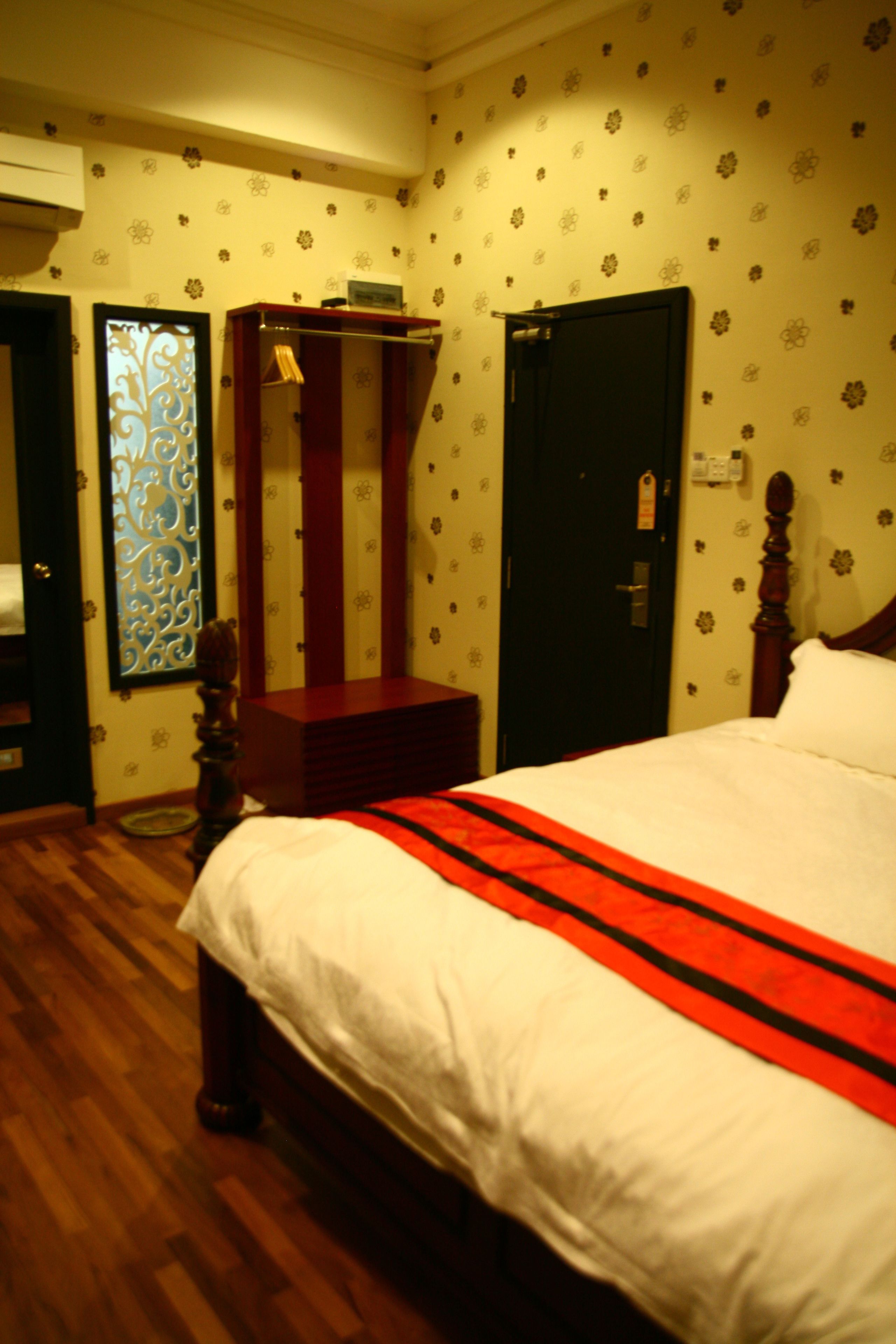 Una habitación de hotel con cama, armario y puerta.