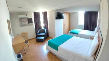 Una camera d'albergo con due letti, una scrivania, una sedia, un condizionatore d'aria e una televisione.