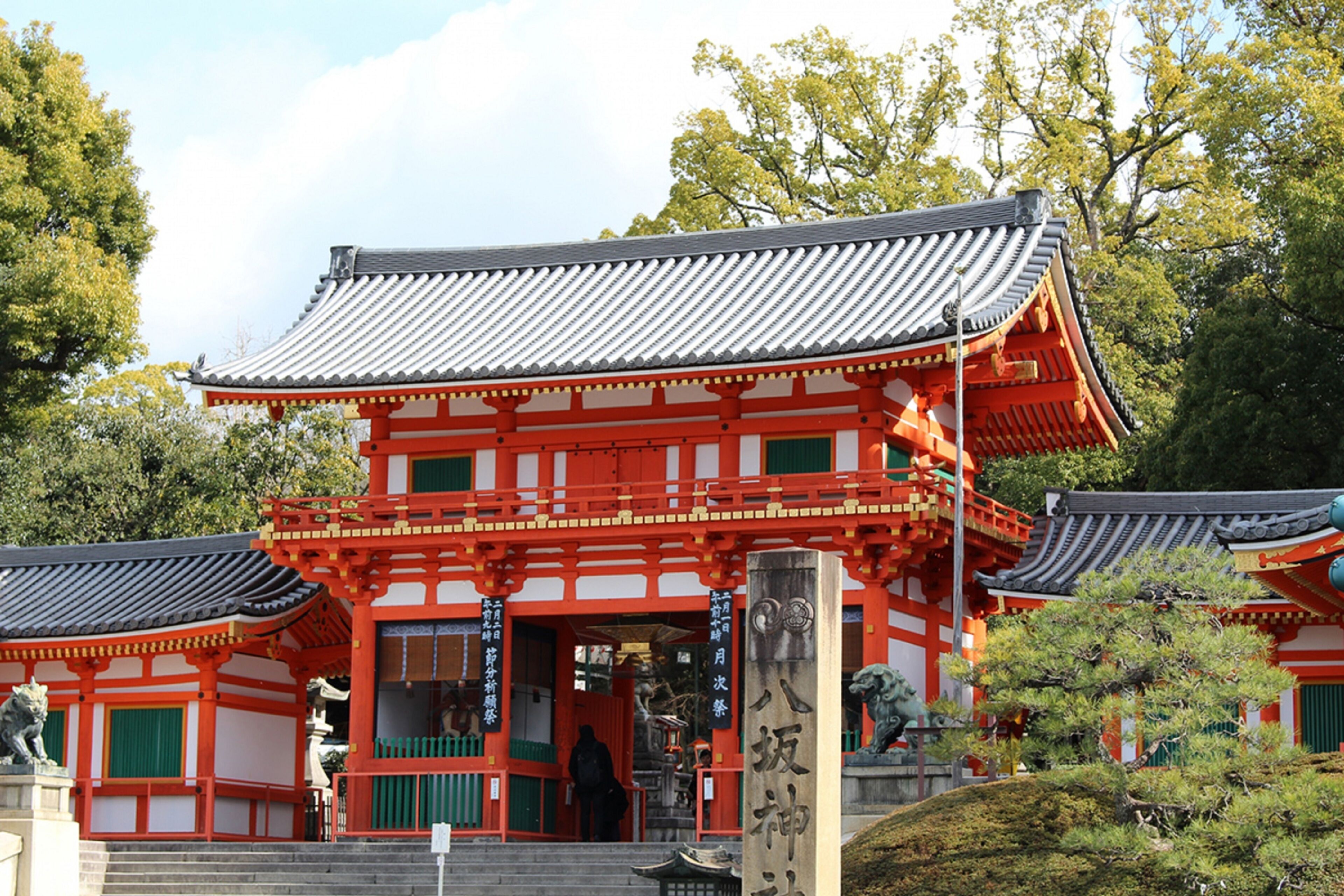 A traditional Japanese building with a red and white color scheme, featuring a curved roof and a prominent entrance.