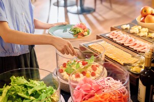 Een buffet met diverse gerechten en een fles wijn.