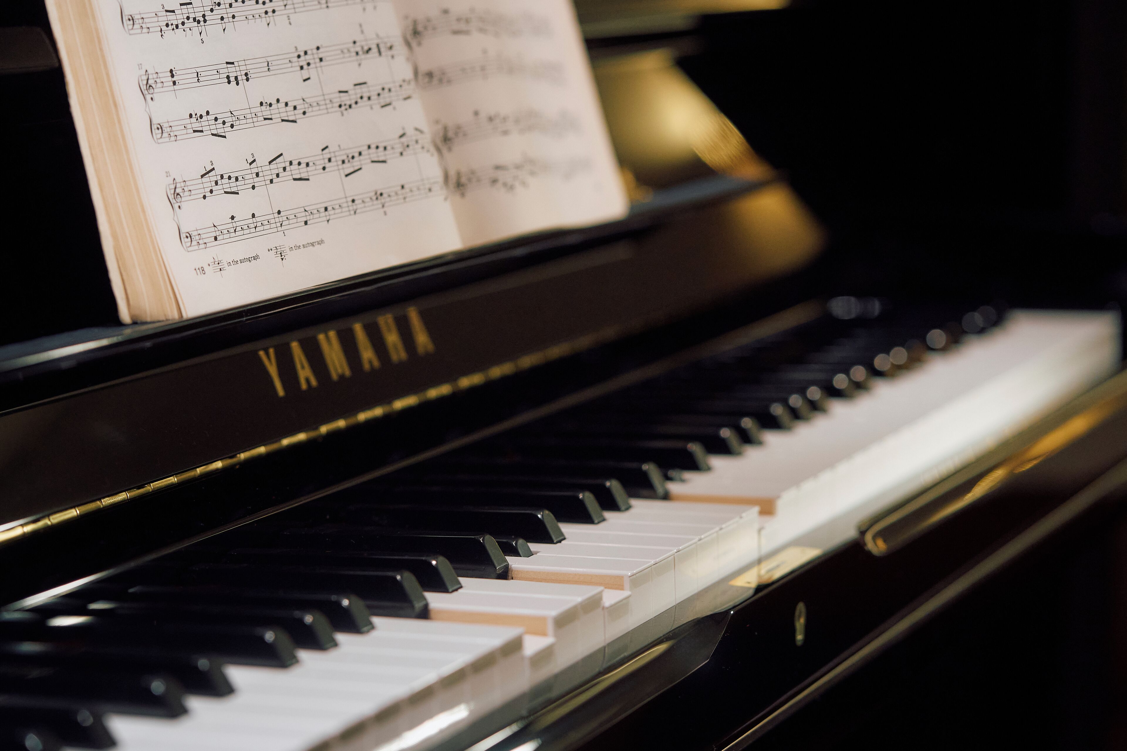 A Yamaha grand piano with sheet music on top.
