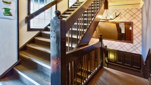 A staircase with a wooden handrail and a wall-mounted deer head decoration. - Albion of Auckland (Auckland)