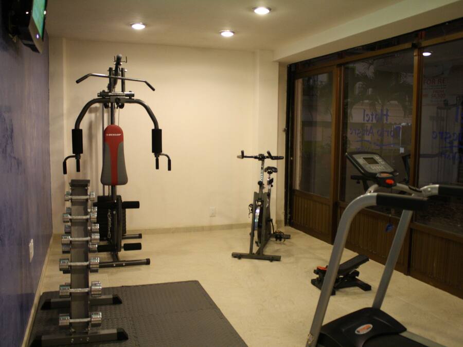 Un gimnasio con equipo de ejercicio, una cinta de correr y una ventana con vistas al exterior.