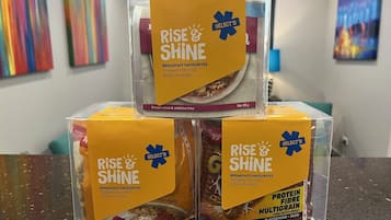 Tres cajas de cereales 'RISE & SHINE' apiladas sobre una encimera.