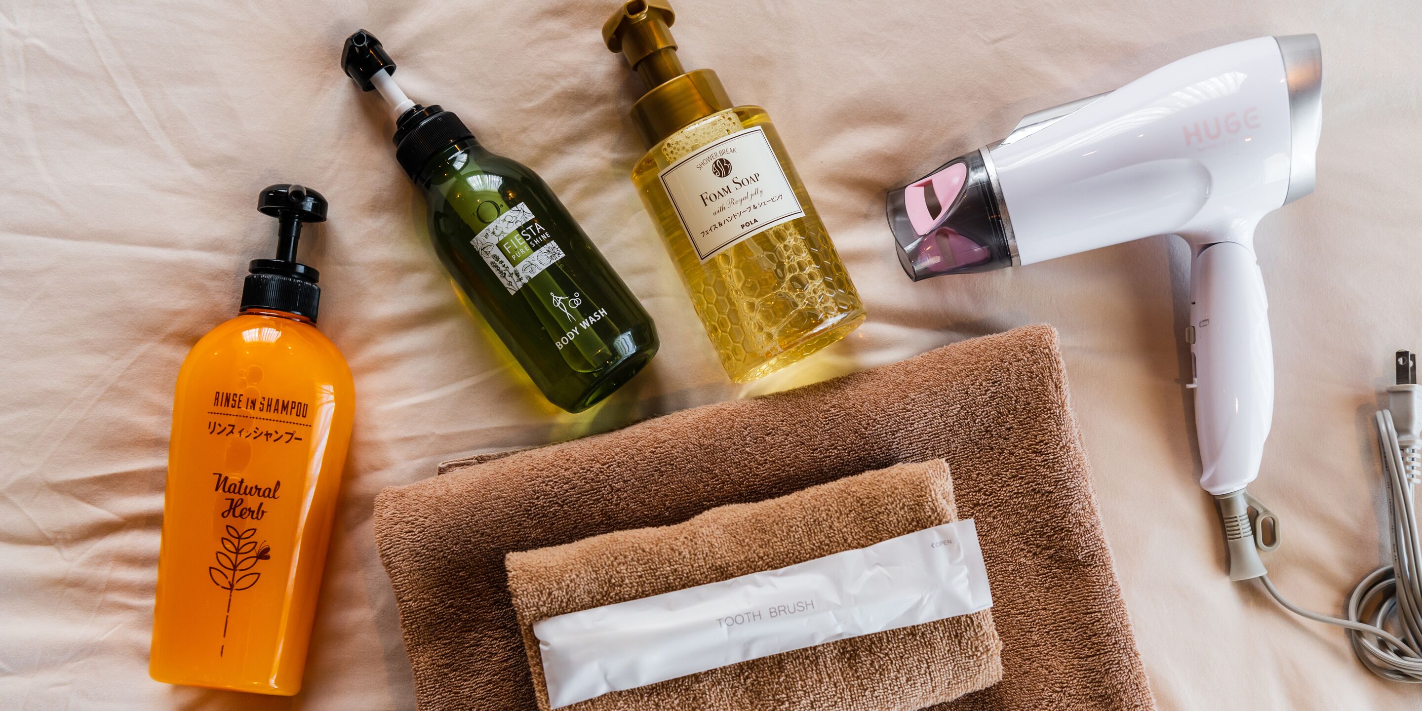 Ein Badezimmer mit Handtuch, Fön, Duschgel, Shampoo und Lotion.